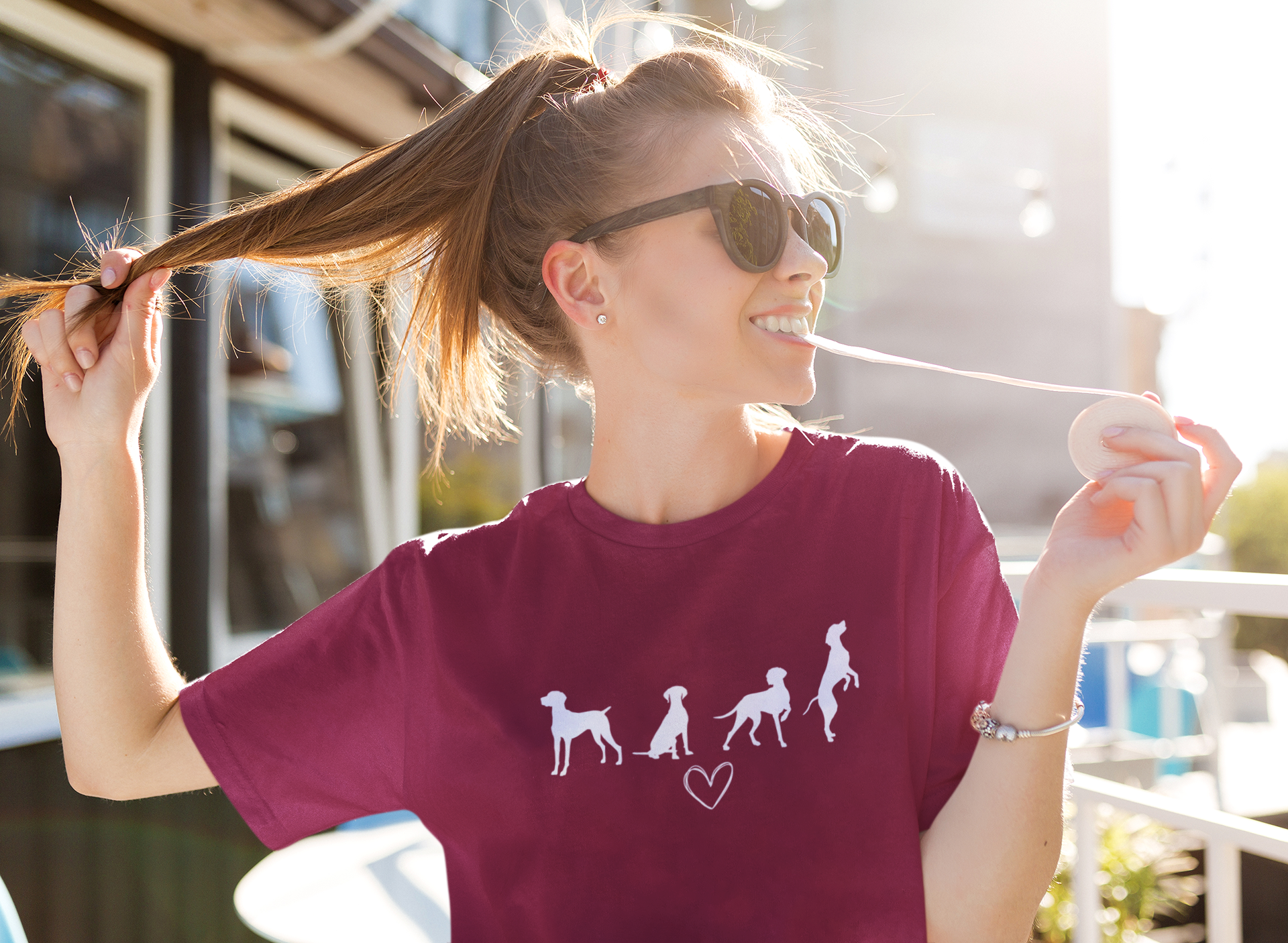 Vrouw in marroon T-shirt met wit silhouet van vier Vizsla-honden en hartje, geschikt voor hondenliefhebbers
