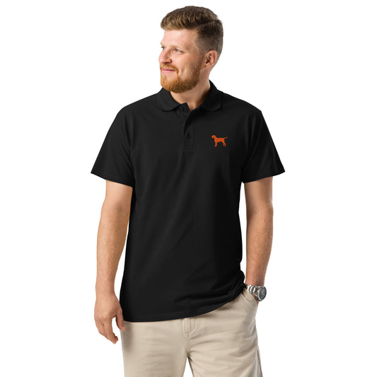 Man met zwarte unisex polo met oranje geborduurde Vizsla Draadhaar op de borst – stijlvol shirt voor jachthonden liefhebbers.